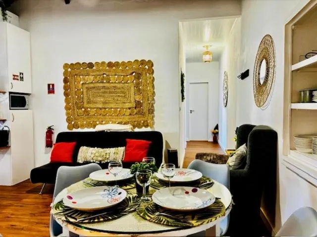 Mesa redonda posta na sala, com quadro dourado na parede